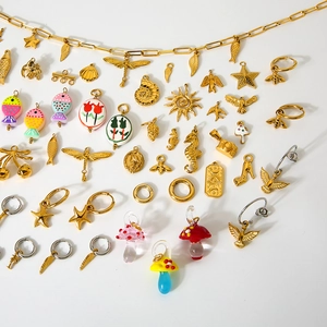 Verschiedene Anhänger aus vergoldetem Edelstahl mit Sternen, Fischen und Tulpenmotiven