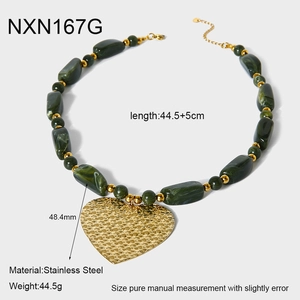 Detailed view of large gold heart pendant with green marbled acrylic beads necklace
