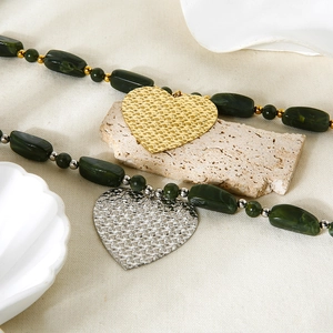 Green acrylic beaded necklace with large gold and silver heart pendants in grid texture
