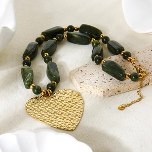 Green acrylic bead necklace with a large gold-plated stainless steel hammered heart pendant