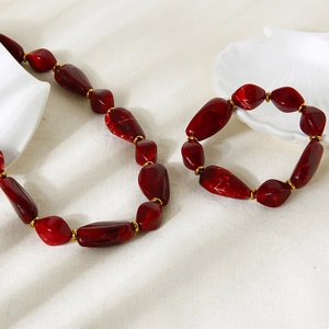 Irregular dark red acrylic beaded necklace and bracelet set with gold-plated spacers