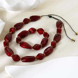 Irregular dark red acrylic beaded necklace and bracelet set with gold-plated spacers