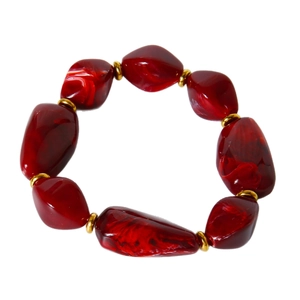 Irregular dark red acrylic beaded bracelet with gold spacers on white background
