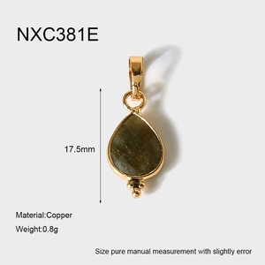 Détail du pendentif goutte en pierre verte facettée avec monture en cuivre doré
