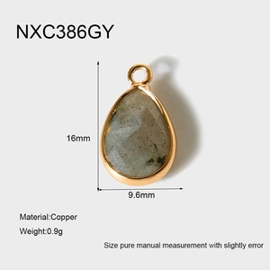 Détail du pendentif goutte en pierre grise facettée avec monture en cuivre doré 18K