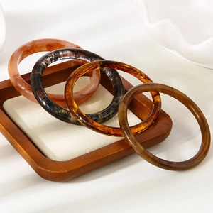 Lot de quatre bracelets joncs vintage en résine avec motifs ambre et marbre sur bois
