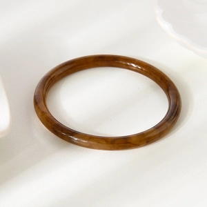 Vue détaillée du bracelet en résine polie avec motif écaille de tortue ambré rétro