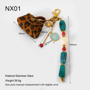 Détail d'un mini sac porte-clés léopard avec lanière en perles et breloque œil bleu