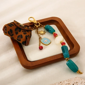 Détail du porte-clés pochette léopard avec perles turquoise et charme de l'œil bleu