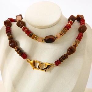 Detail of beaded necklace with brown gemstones and golden double lobster clasps