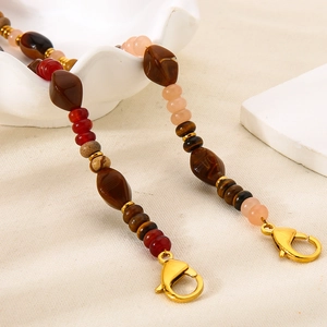 Detail of beaded strap with tiger eye and red agate stones featuring gold lobster clasps