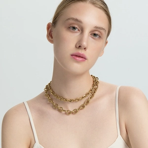 Detail van 18K vergulde dubbellaagse roestvrijstalen pantserketting met OT-sluiting op het model