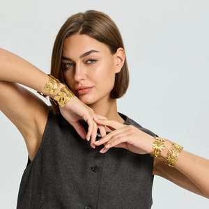 18K gold plated flower and ginkgo leaf stainless steel open bracelets on a model's wrist