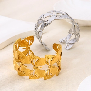 Macro shot of 18K gold and silver hollow butterfly open cuff bracelets in detail