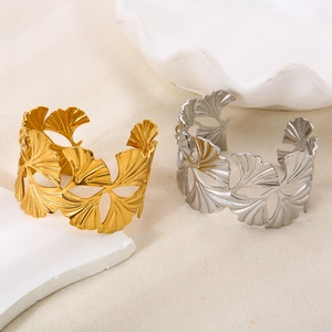 Detailed view of hollow ginkgo leaf cuff bracelet in 18K gold and silver finishes