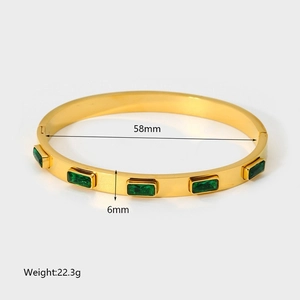 Detail view of 18K gold plated stainless steel bangle with five green zircon stones