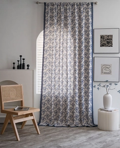 Detail of vintage floral curtain with blue lace trim on textured cotton linen fabric