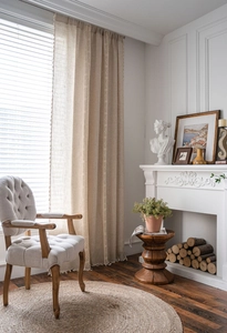 Close-up of natural linen curtain with lace cutout embroidery and tassel fringe details