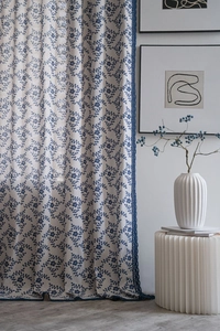 Detail of French vintage curtains featuring blue floral embroidery and delicate lace trim