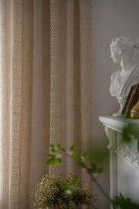 Detail of French vintage beige linen curtain featuring delicate lace stitching and texture