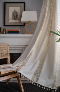 Detailed shot of cream retro curtain with hollow lace stitching and elegant tassels