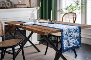 Détail du chemin de table Toile de Jouy bleu et blanc avec bordure en dentelle bleue marine