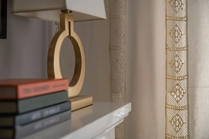 Detail view of the elegant golden metal ring base and white fabric lampshade on table