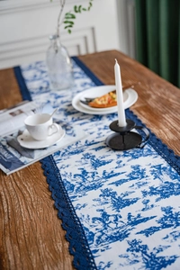 Détail du chemin de table Toile de Jouy avec dentelle bleue sur bois rustique
