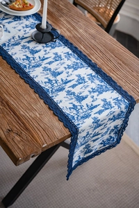 Détail du chemin de table Toile de Jouy avec bordure en dentelle au crochet bleu