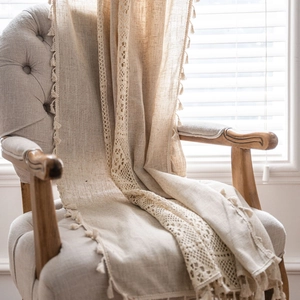 Linen boho curtain with hollow crochet lace and tassel fringe on a cozy armchair
