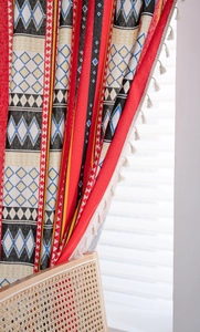 Detailed close-up of Bohemian curtain fabric with geometric patterns and white tassels