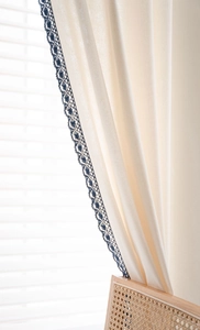 Detail of white cotton linen curtain with navy blue hollowed-out crochet lace edge