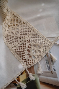 Detailed macro view of the hand-woven hollow geometric pattern with fringe on the curtain