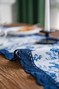 Gros plan détaillé du chemin de table à fleurs bleues avec bordure en dentelle ajourée