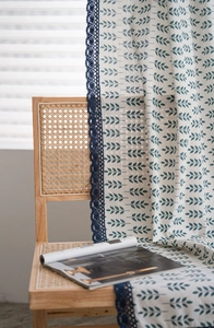 Détail de rideau en coton lin à imprimé feuilles avec bordure en dentelle au crochet bleu