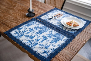 Gros plan sur les sets de table Toile de Jouy avec bordure en dentelle crochetée bleu