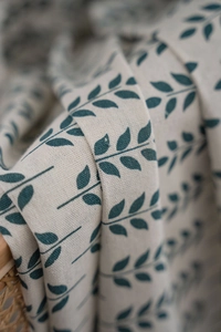 Détail de l'imprimé feuilles vertes sur tissu en lin et coton beige au tissage naturel