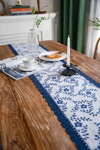Detail of floral printed table runner with elegant dark blue crochet lace trim edges