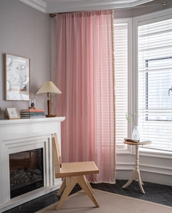 Close-up of pink linen blend curtain with embroidery and cream tassel fringe trim