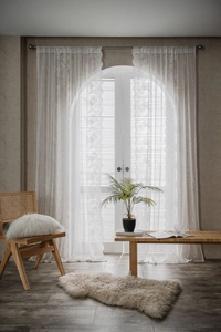 Macro shot of semi-transparent white floral lace curtains with scalloped wavy edges