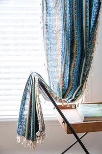 Detail of bohemian yellow striped curtains with cotton linen texture and white tassels
