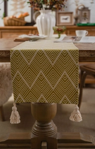 Macro shot of yellow geometric table runner texture with woven fringe tassels on wood