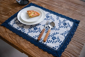 Close-up of navy blue floral table runner with lace edges on a dark wooden dining table