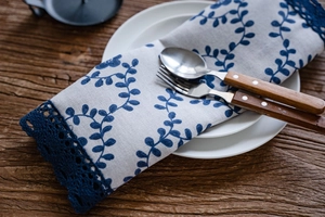 Close-up of navy floral table runner with blue lace edge on rustic wooden table