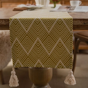 Nordic bohemian geometric table runner with tassels on a dark wood dining table