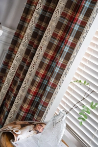 Detail of retro red and brown plaid curtain with lace crochet and fringe tassels