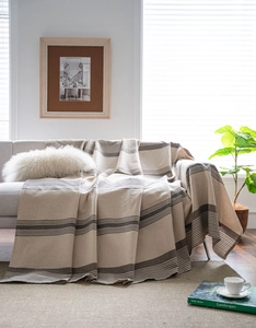 Detail of coffee brown striped sofa cover with thick woven texture on a grey couch