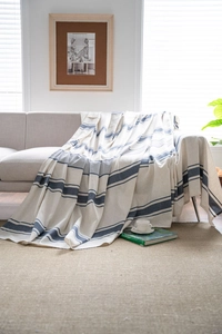 Modern navy blue striped sofa throw blanket with cotton texture in a cozy home setting