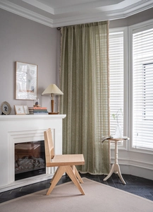 Detail of sage green cotton linen curtain featuring woven stripes and frayed edges