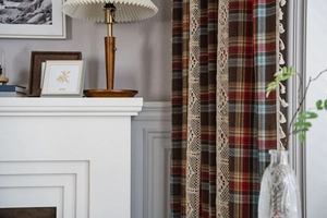 Detailed close-up of retro plaid curtain with white geometric lace and tassel fringe trim